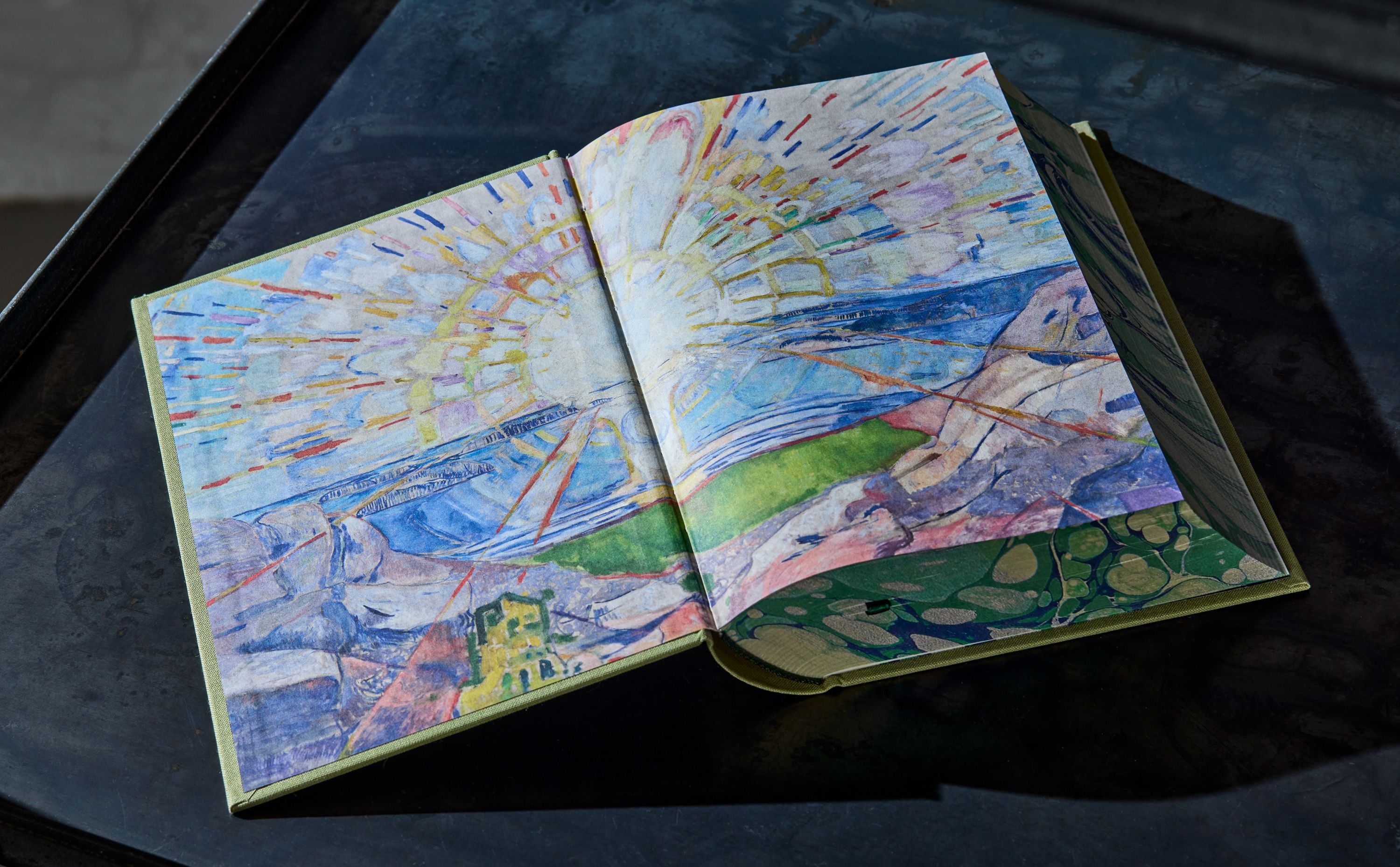 Oppslag av en bibel som viser "Solen" av Munch printet på innsiden av coveret til en bok