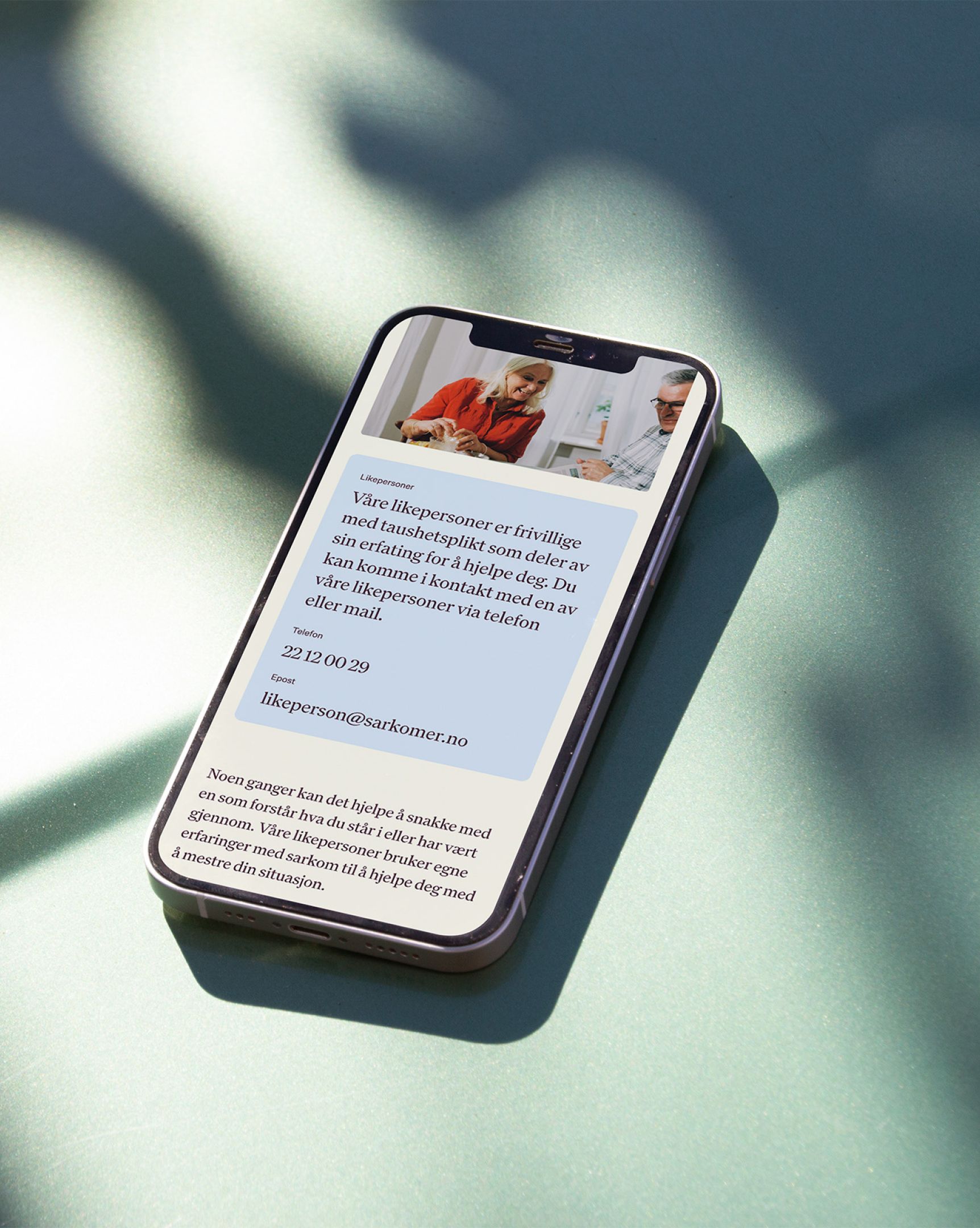 Bilde av en iphone med sarkomer sin nettside oppe.
