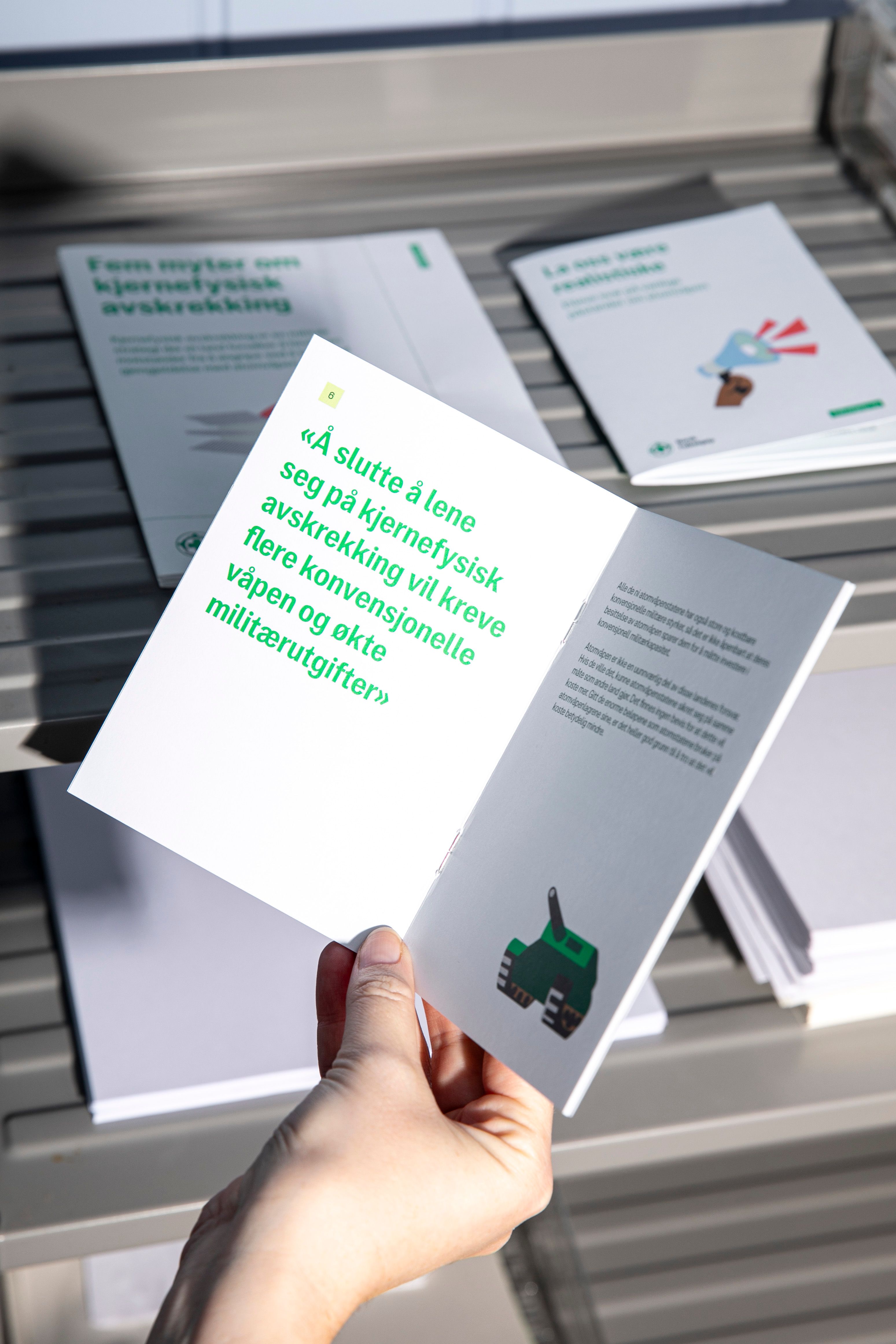 En som holder en brosjyre fra Norsk Folkehjelp