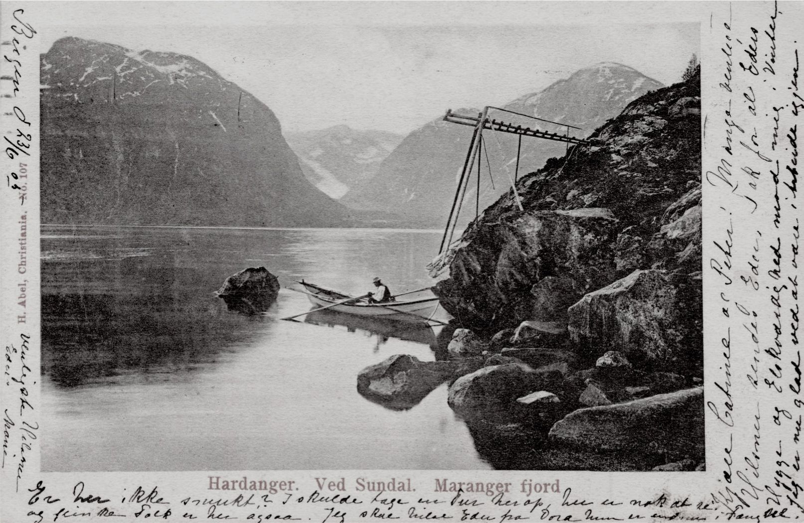 Gammelt postkort. Mann sitter i båt i Maranger fjord i Hardanger, ved Sundal.
